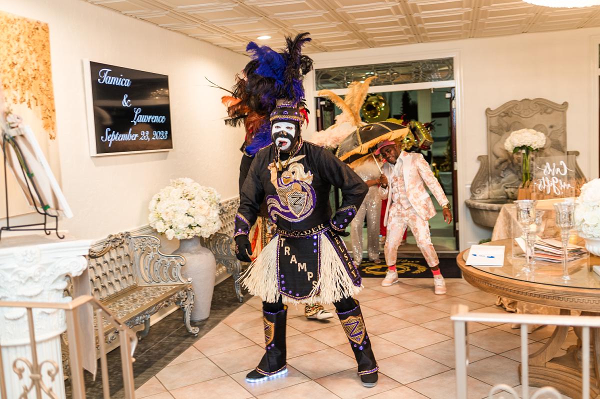 Members of the Krewe of Zulu lead the second line through Champagne Palace's ballroom