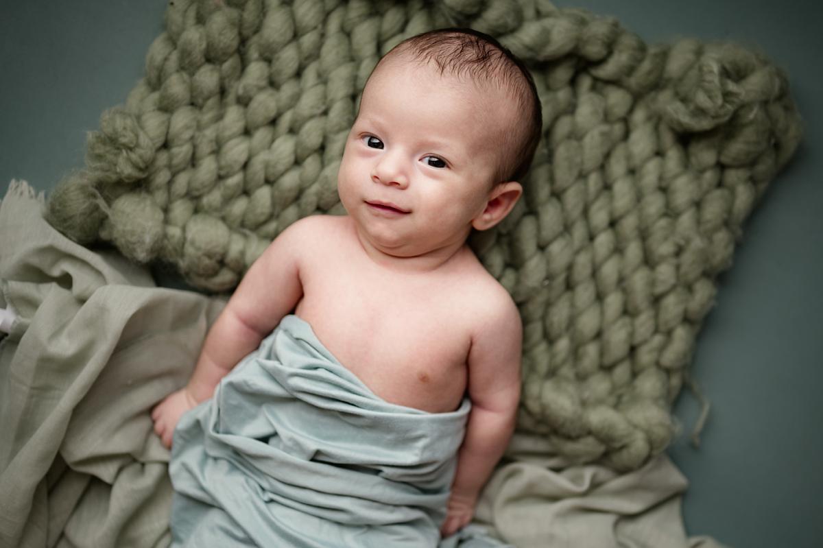 Newborn photography session in Houma featuring a 2-month-old baby’s adorable expressions
