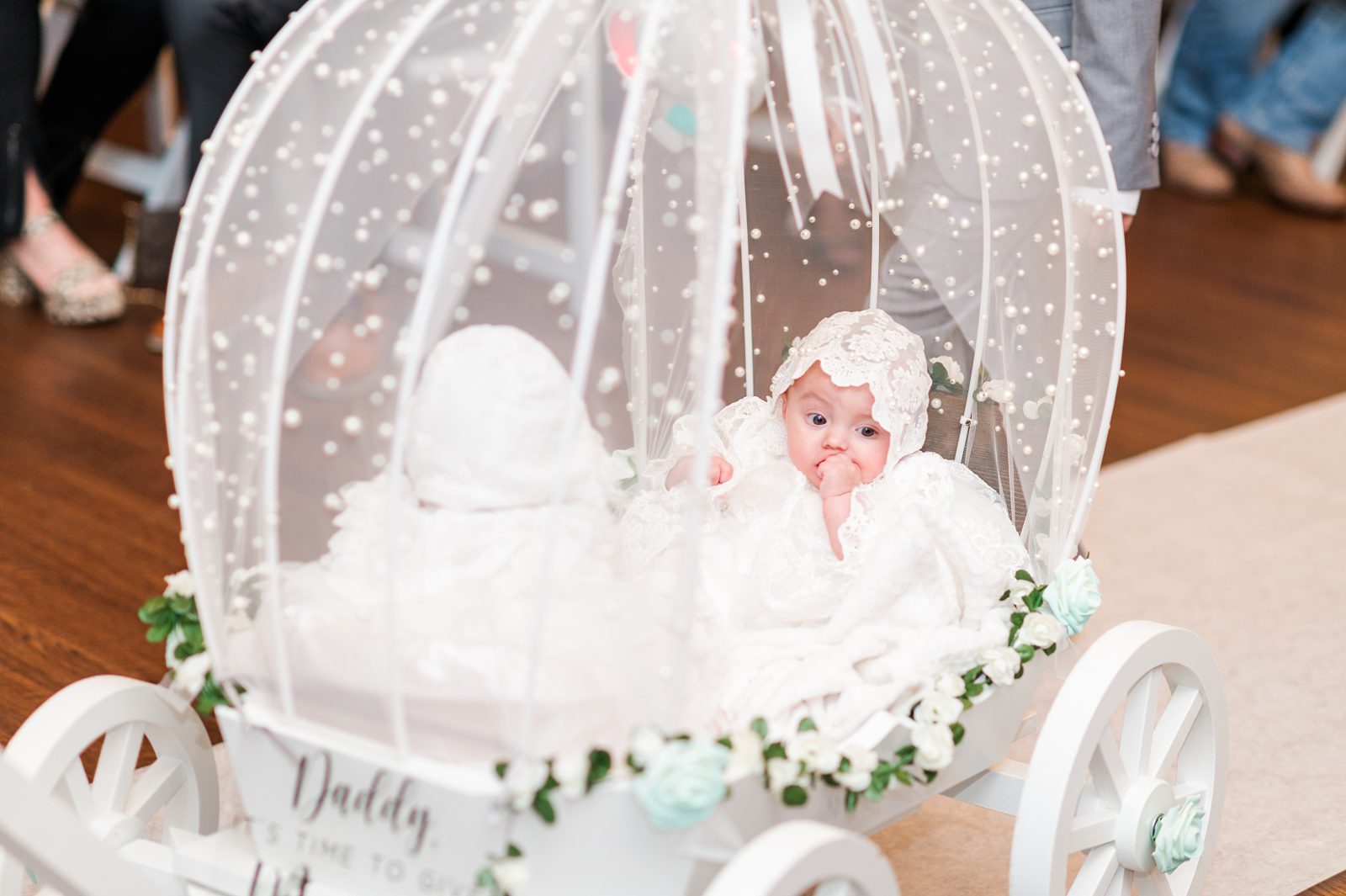 Adorable baby girls pulled in a decorated carriage down the wedding aisle